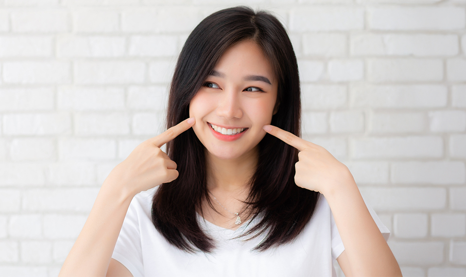 Woman pointing at her smile