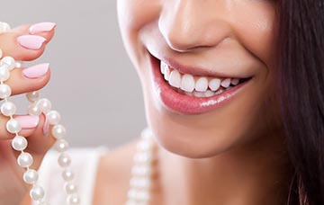 A women smiling at her white pearls